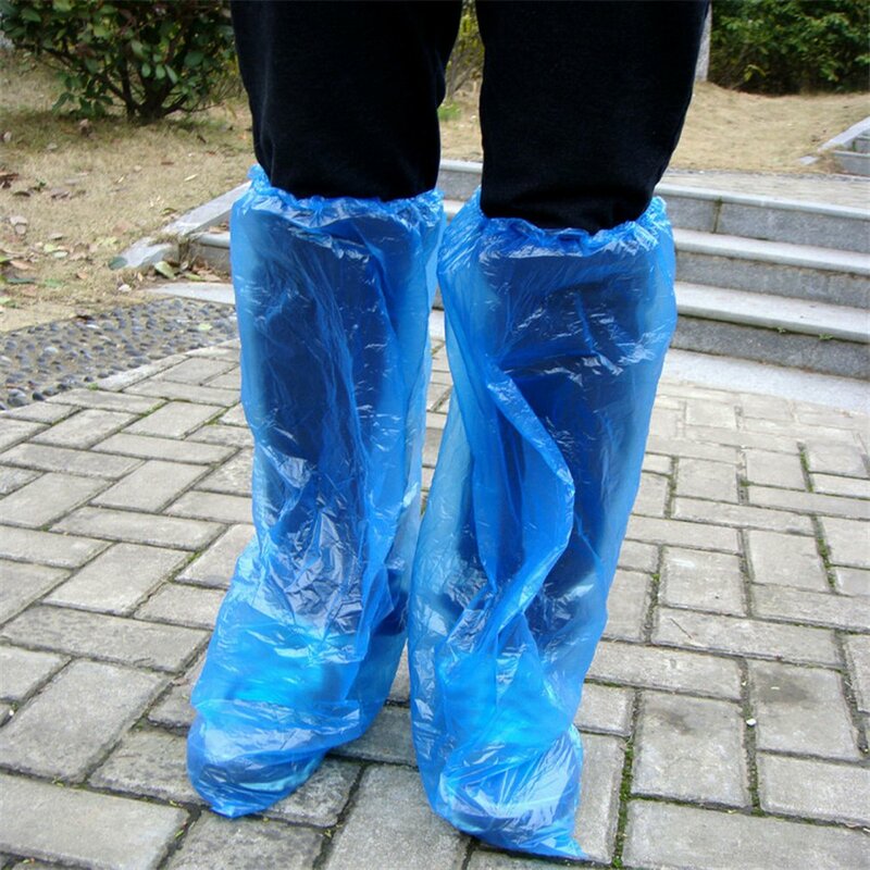 A sapata plástica descartável cobre as sapatas azuis da chuva e as botas cobrem a sapata longa plástica clara impermeável antiderrapante overshoe