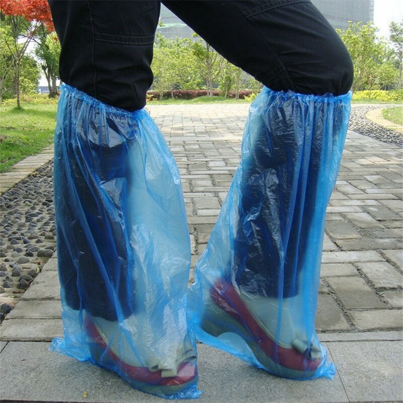 A sapata plástica descartável cobre as sapatas azuis da chuva e as botas cobrem a sapata longa plástica clara impermeável antiderrapante overshoe