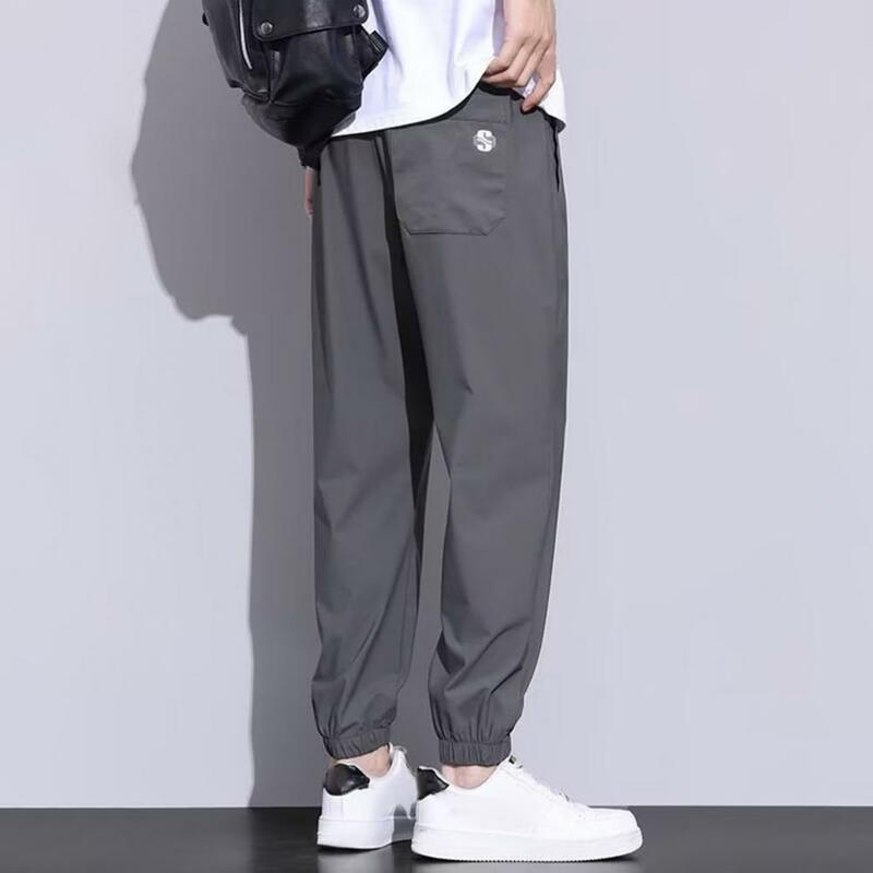 Celana olahraga pria, cepat kering dengan kantong samping pinggang elastis untuk latihan Gym Jogging longgar sesuai mata kaki