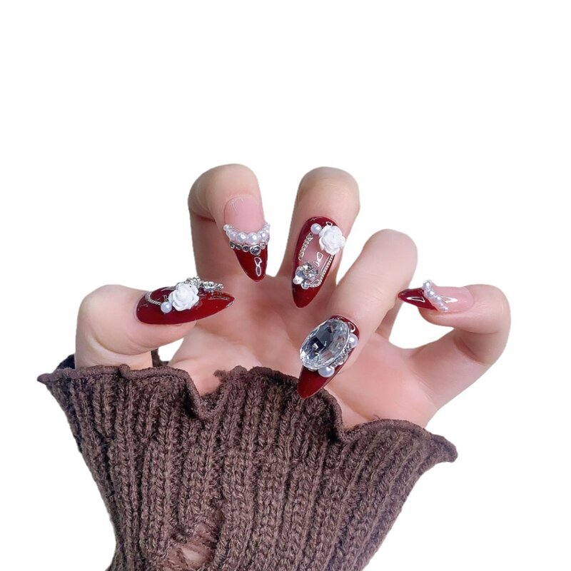 Manicure indossata a mano, ghiaccio rosso vino di lusso leggero attraverso camelia, diamanti e flash, unghie di mandorle di fascia alta fatte a mano