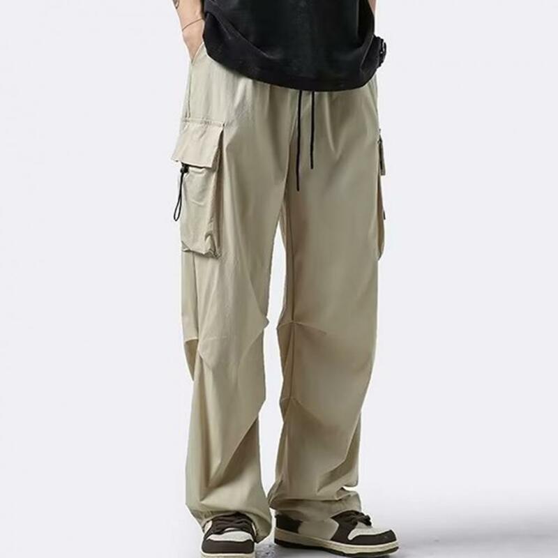 Celana olahraga pria, celana kargo kaki lurus banyak saku dengan tali serut Detail pinggang elastis pakaian jalanan untuk luar ruangan