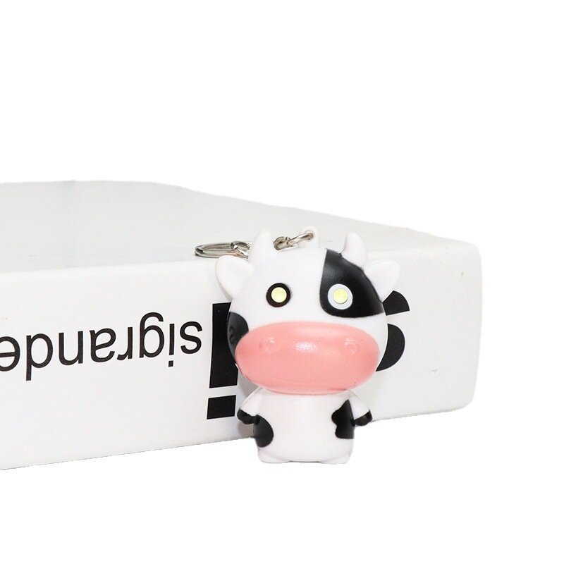 Llavero colgante de vaca emisor de luz de dibujos animados Kawaii, colgante de coche de pantorrilla lindo creativo, colgante de mochila con sonido emisor de luz