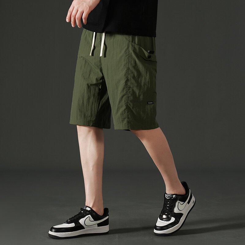 Celana pendek kasual berenda elastis untuk pria, pakaian pendek selutut lurus longgar netral dengan saku warna polos Musim Panas 2024