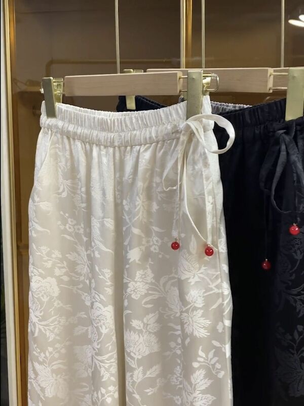 Pantaloni a gamba larga in raso bianco per donna 2024 pantaloni larghi estivi a vita alta con fiori stampati nuovi pantaloni alla caviglia da donna con lacci