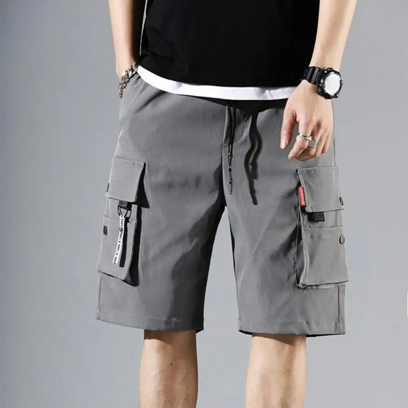 Pantalones cortos de Color liso para hombre, Shorts Cargo deportivos de verano con pretina elástica, varios bolsillos, anchos