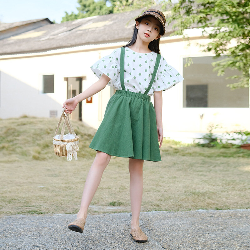 เซ็ตเสื้อผ้าสำหรับนักเรียนเด็กผู้หญิงสูทสไตล์สไตล์เกาหลีฤดูร้อน2024ชุดเสื้อผ้าแขนจีบมีจุด + กระโปรงสายเอี๊ยม
