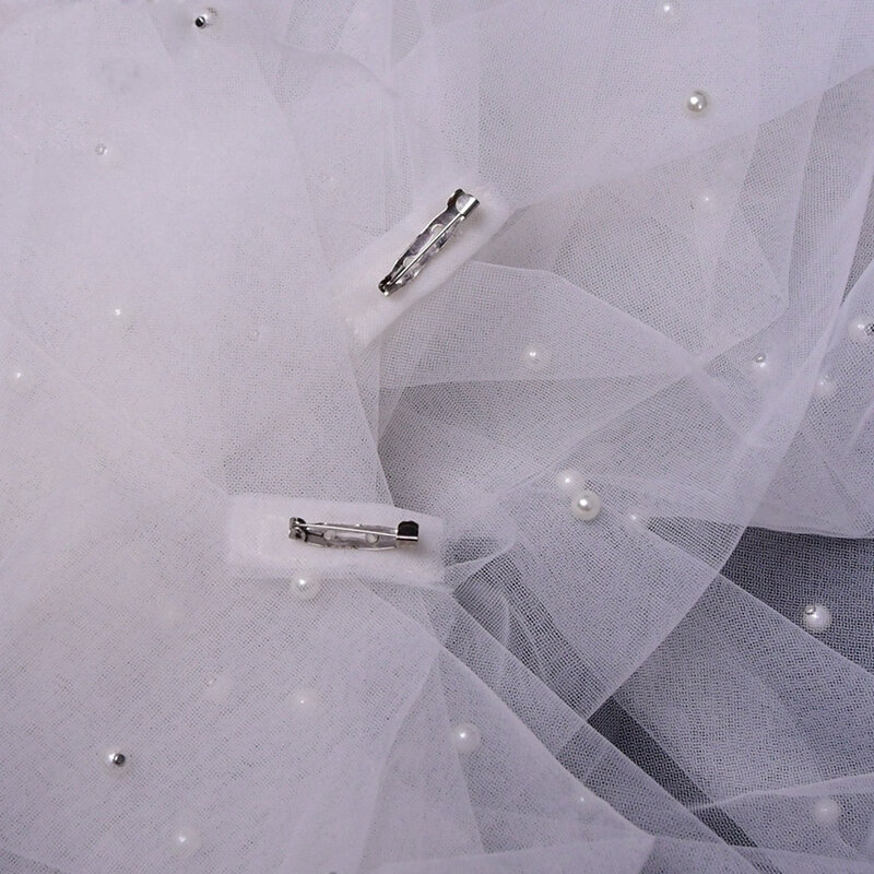 真珠のピンが付いている長くてふくらんでいる結婚式のロングジャケット