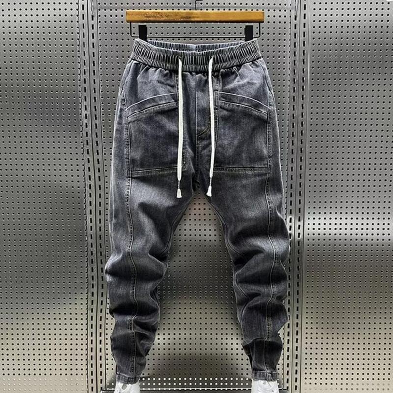 Celana panjang Jeans elastis pria, celana panjang pinggang tali serut desain kantung warna Solid kasual Harem