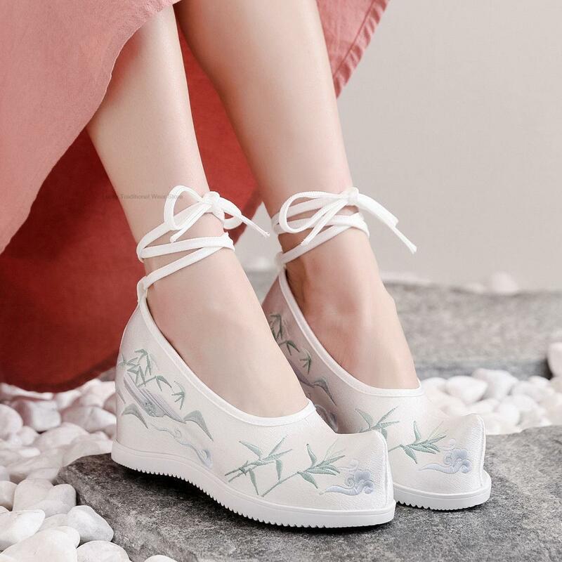 รองเท้าสตรีปักแบบจีนดั้งเดิมสำหรับผู้หญิงรองเท้าสไตล์ชาติพันธุ์รองเท้าผู้หญิงสีขาวบริสุทธิ์รองเท้า Hanfu เพิ่มความสูงให้รองเท้าผูกเชือก