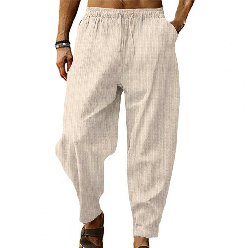 Celana panjang pinggang sedang pria, bawahan olahraga bergaris kaki lebar dengan tali serut, pinggang elastis lembut bernafas untuk nyaman