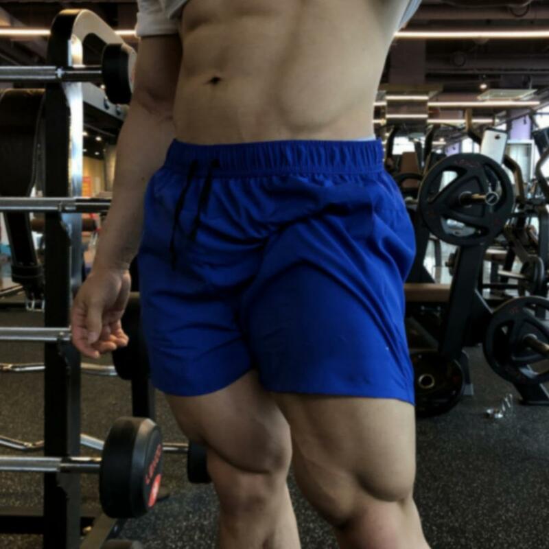 Calções esportivos masculinos de secagem rápida com elástico na cintura, shorts largos de cor sólida, musculação fitness verão