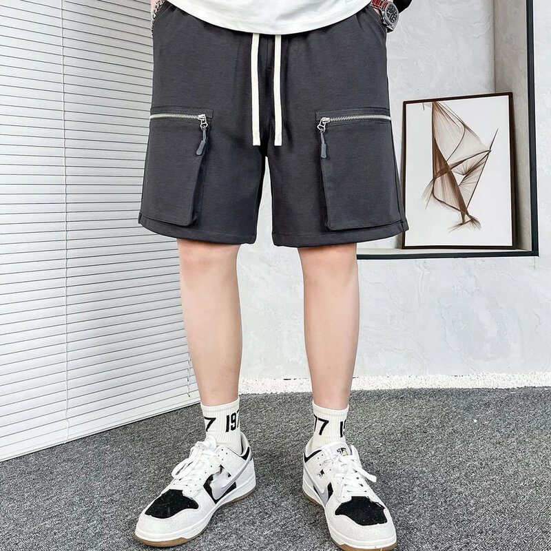 Celana pendek selutut bersaku ritsleting pria, bawahan pinggang elastis Hip Hop longgar sesuai Harem Streetwear musim panas