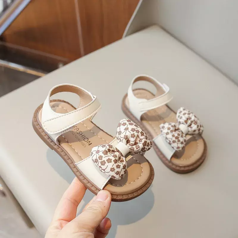 Nowe sandały dziecięce dla dziewczynek letni kwiat muszka księżniczka przyczynowa modne płaskie sandały dziecięce sandały plażowe z odkrytymi palcami miękkie dno