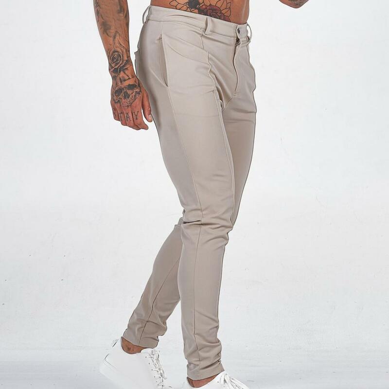 กางเกงเข้ารูปสีทึบของผู้ชายกางเกงธุรกิจสีพื้นเอวกลางระบายอากาศได้ยาวถึงข้อเท้านุ่ม Bahan Kain tipis
