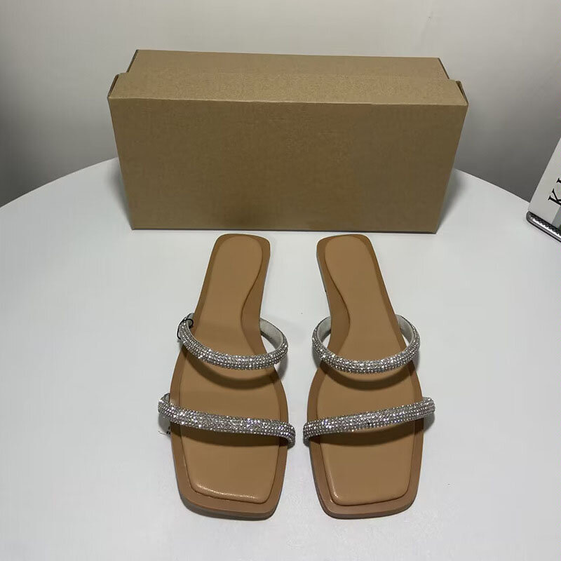 Square head with rhinestone embellishments and exposed toes flat bottomed and worn in sandals for women