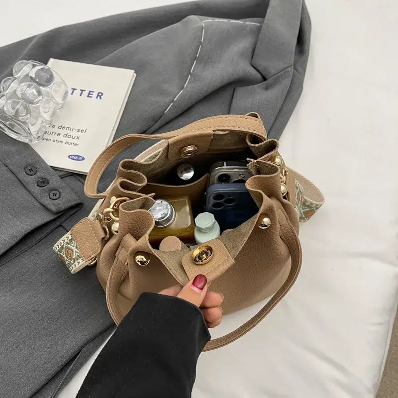 Bolsa de textura versátil para mulheres, bolsa crossbody casual, bolsa de balde de mão, sacola, design high-end, moda coreana, nova, 2024
