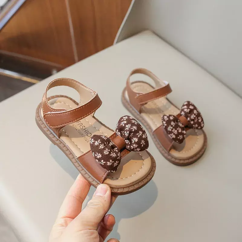 Nowe sandały dziecięce dla dziewczynek letni kwiat muszka księżniczka przyczynowa modne płaskie sandały dziecięce sandały plażowe z odkrytymi palcami miękkie dno
