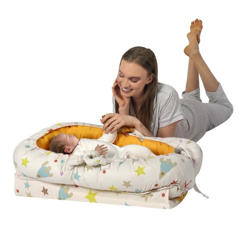 Cream colored rocket patterned mother side baby bed