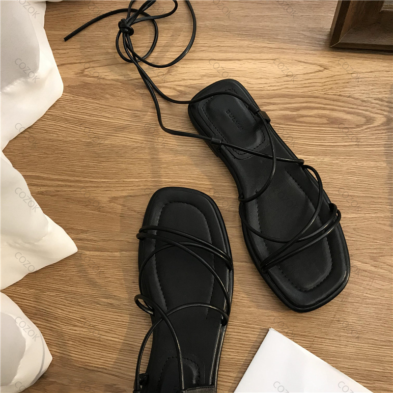Sandały damskie letnie nowe 2024 moda plażowa seksowne płaskie na co dzień z wystającym palcem styl bajki wąskie paski buty czarne rzymskie sandały