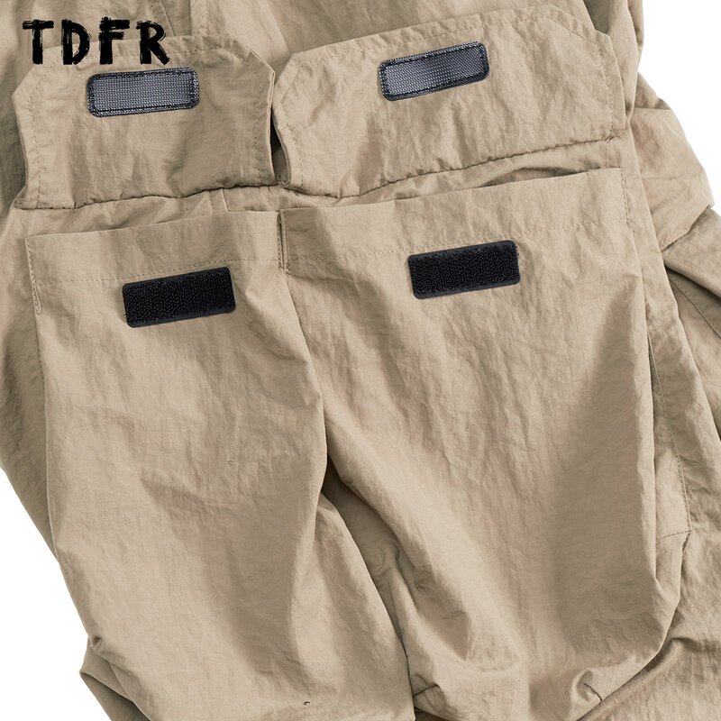 กางเกงคาร์โก้มีกระเป๋าสำหรับผู้ชายกางเกงขากว้างเอวยางยืดปรับได้สีพื้นสไตล์ซาฟารีทรงหลวมสำหรับผู้ชาย