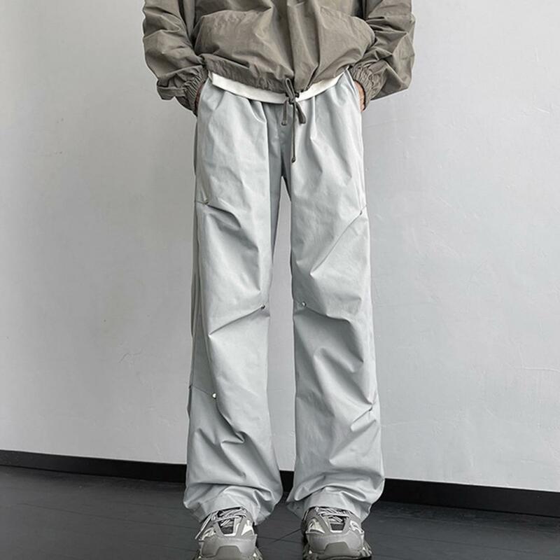 Celana olahraga pria, celana kaki lurus Unisex bergaya celana kargo dengan dekorasi keling lebar longgar pas desain tahan air untuk Streetwear