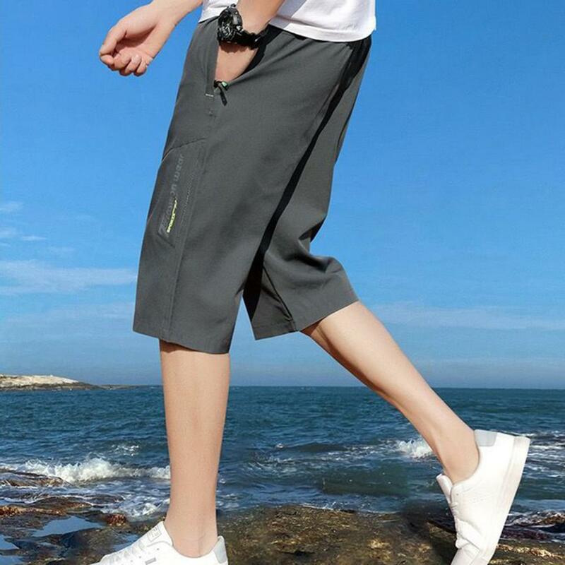 Celana crop warna Solid pria, bawahan pinggang elastis dengan saku ritsleting, celana panjang setengah betis bernapas lembut