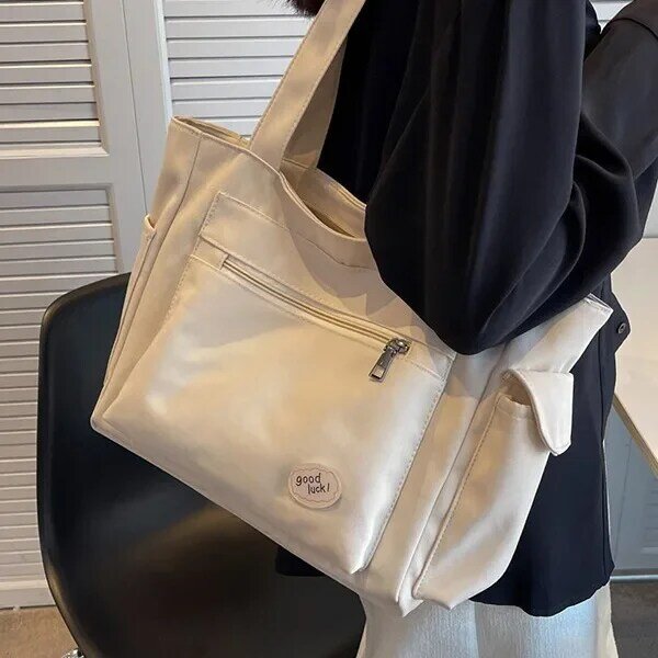กระเป๋าผ้าใบแคนวาสสำหรับผู้หญิงชั้นเรียนของนักเรียนวิทยาลัยจุได้เยอะ tas Jinjing bahu แบบเรียบง่ายแฟชั่นใหม่2024