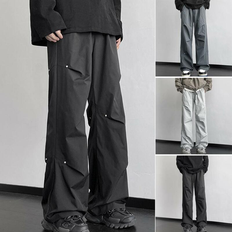 Celana olahraga pria, celana kaki lurus Unisex bergaya celana kargo dengan dekorasi keling lebar longgar pas desain tahan air untuk Streetwear